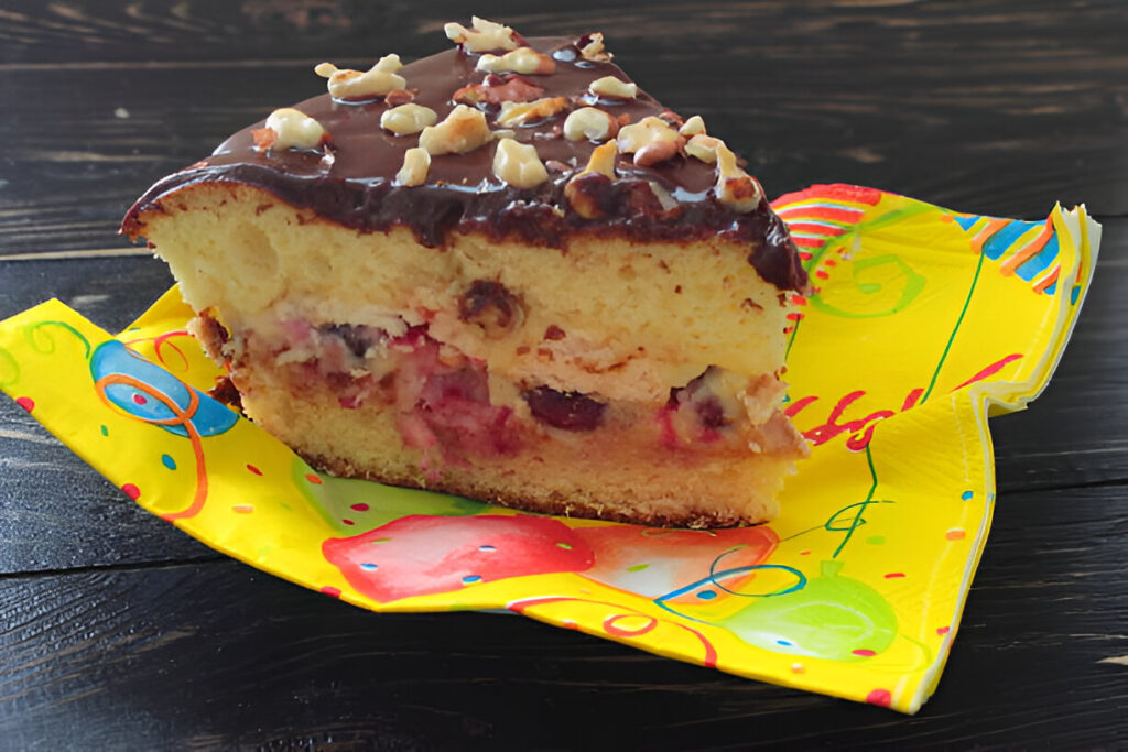 A slice of poke cake showing its moist interior with sauce-infused layers, topped with whipped cream and caramel drizzle.